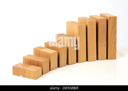 Holzblöcke sind wie eine Karte oder eine Treppe auf weißem Hintergrund aufgebaut Stockfoto