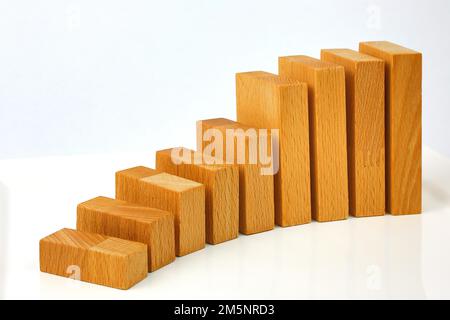 Holzblöcke sind wie eine Karte oder eine Treppe auf weißem Hintergrund aufgebaut Stockfoto