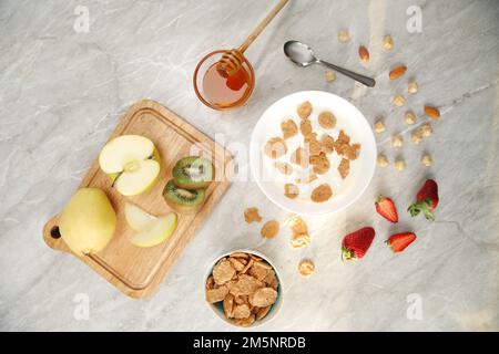 Cornflakes Schale neben Erdbeeren auf weißem Hintergrund Stockfoto