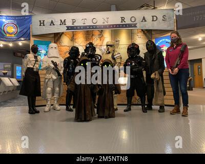 Darcy Sink (ganz rechts), steht für ein Foto mit Mitgliedern der Semper Tyranus Garnison der 501. Legion, einer Organisation, die Star Wars-Kostümbildner ist und kürzlich das Hampton Roads Naval Museum besucht hat. Die Gruppe hatte die Gelegenheit, einen Spaziergang durch die Galerie des Museums im Rahmen einer Veranstaltung in Nauticus in Norfolk, Virginia, zu machen. Stockfoto