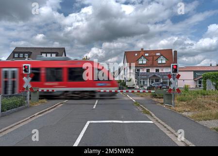 Vorstadtbahn an einem Bahnübergang mit Barrieren, Eckental, Mittelfrankreich, Bayern, Deutschland Stockfoto