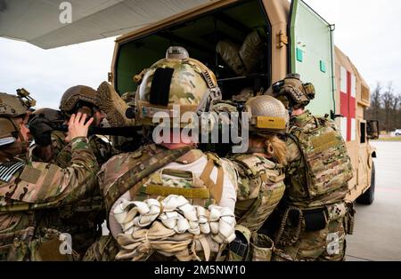 Hinweis: Dies ist eine simulierte Übung. Ein US Army austere Resuscitative and Surgical Care Team, das dem Special Operations Command Europe und Pararescuemen zugewiesen wurde, die dem 352d Special Operations Wing zugeteilt wurden, transportiert einen simulierten Patienten aus einem MC-130J Commando II in einen Krankenwagen, während einer medizinischen Übung in Polen, 26. Februar 2022. Das US-Sondereinsatzkommando Europa ist bereit und strategisch positioniert, um die NATO-Alliierten und -Partner rasch zu unterstützen und sich gegen jede Aggression zu verteidigen, um die Stabilität und Sicherheit in Europa aufrechtzuerhalten. Stockfoto