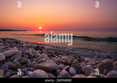Später Sonnenuntergang über dem Wellenmeer am Acharavi Beach, Korfu Stockfoto