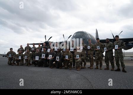 US-Militärangehörige, die auf dem Luftwaffenstützpunkt Kadena stationiert sind, haben Fotos von gefallenen Militärangehörigen vor einem MC-130J Commando II, das dem 1. SOS am 26. Februar 2022 zugeteilt wurde. Dieses Jahr repräsentierten 23 Mitglieder des Dienstes, sowohl im Dienst als auch im Rang, jede Person an Bord eines MC-130E, der dem 1. SOS, Rufzeichen STREU 59, zugewiesen wurde, der 1981 abstürzte. Stockfoto