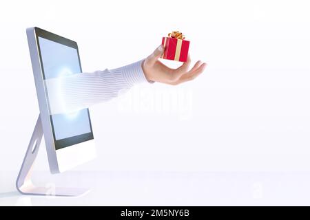 Eine männliche Hand, die vom Computerbildschirm ausstreckt und eine rote Geschenkbox in der Hand hält. Valentinstag, Frauen, Muttertag, Geburtstagsfeiertage 3D Grußkarte komposita Stockfoto