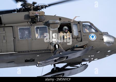 Eine Alaska Army National Guard UH-60 Blackhawk, die während einer gemeinsamen Feldübungsübung in Camp Mad Bull auf der gemeinsamen Basis Elmendorf-Richardson, Alaska, am 26. Februar 2022 in die Luftwaffenwache der 207. Luftregistrierung und die Luftwaffe eingeteilt wurde. Die Übung umfasste Lufttransporteinsätze, den Bau von arktischen Verteidigungspositionen und einen simulierten Angriff mit Kleinwaffen, um die Reaktionen der Luftwaffe und des Personals der Nationalgarde der Alaska-Armee zu bewerten und zu verstärken. Gemeinsame Übungen zeigen die Zusammenarbeit, verbessern die Interoperabilität und verstärken die Abschreckung. Stockfoto