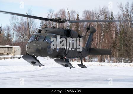 Eine Alaska Army National Guard UH-60 Blackhawk, die während einer gemeinsamen Feldübungsübung in Camp Mad Bull auf der gemeinsamen Basis Elmendorf-Richardson, Alaska, am 26. Februar 2022 in die Luftwaffenwache der 207. Luftregistrierung und die Luftwaffe eingeteilt wurde. Die Übung umfasste Lufttransporteinsätze, den Bau von arktischen Verteidigungspositionen und einen simulierten Angriff mit Kleinwaffen, um die Reaktionen der Luftwaffe und des Personals der Nationalgarde der Alaska-Armee zu bewerten und zu verstärken. Gemeinsame Übungen zeigen die Zusammenarbeit, verbessern die Interoperabilität und verstärken die Abschreckung. Stockfoto
