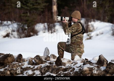 Air Force Airman 1. Class Patrick Sullivan, Fotojournalist beim 673d Air Base Wing Public Affairs Office, fotografiert eine gemeinsame Feldübungsübung im Camp Mad Bull, Joint Base Elmendorf-Richardson, Alaska, 26. Februar 2022. Die Air Force-Ingenieure der 673d Civil Engineer Group und die Alaska Army National Guardsmen mit der 207. Engineer Utility Disposition führten die gemeinsame Einsatzschulung durch, um ihre Fähigkeiten in arktischen Bedingungen unter Beweis zu stellen. Die Übung umfasste Lufttransportoperationen, den Bau von arktischen Verteidigungspositionen und ein simuliertes kleines A. Stockfoto