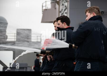 Matrosen, die der Luftwaffe der USS Gerald R. Ford (CVN 78) zugewiesen sind, führen am 27. Februar 2022 hydrostatische Tests an Feuerlöschschläuchen im Cockpit durch. Ford ist im Atlantik im Einsatz, nachdem der industrielle Teil einer sechs Monate dauernden geplanten zusätzlichen Verfügbarkeit (PIA) abgeschlossen wurde. Stockfoto