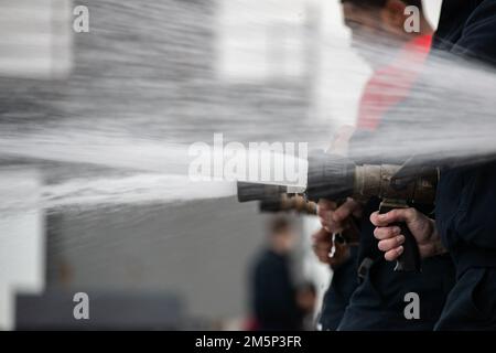 Matrosen, die der Luftwaffe der USS Gerald R. Ford (CVN 78) zugewiesen sind, führen am 27. Februar 2022 hydrostatische Tests an Feuerlöschschläuchen im Cockpit durch. Ford ist im Atlantik im Einsatz, nachdem der industrielle Teil einer sechs Monate dauernden geplanten zusätzlichen Verfügbarkeit (PIA) abgeschlossen wurde. Stockfoto