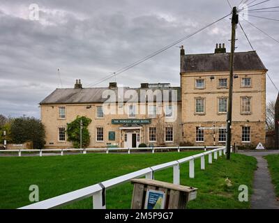 Ein bedeckter Novembernachmittag und das Worsley Arms Hotel an der B1257. Straße bieten einen herzlichen Empfang in Hovingham, North Yorkshire Stockfoto