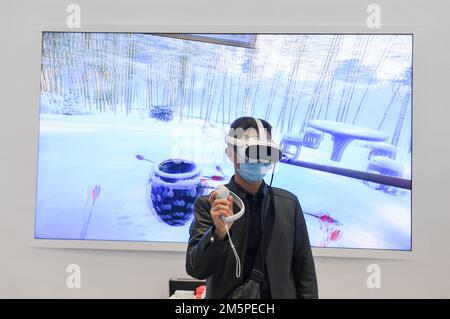 (221230) -- SHENZHEN, 30. Dezember 2022 (Xinhua) -- Ein Mann versucht ein Virtual-Reality-Gerät auf der 18. China (Shenzhen) International Cultural Industries Fair in Shenzhen, Südchina Guangdong Provinz, 29. Dezember 2022. Ausstellungen auf der Messe, die mit modernsten Technologien ausgestattet sind, ziehen Besucher an. (Xinhua/Mao Siqian) Stockfoto