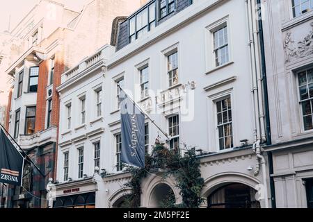 London, Vereinigtes Königreich - 26. Dezember 2022: Name und Flagge auf dem Gebäude von Sotheby's, einem der weltweit größten Makler für Kunst- und Dekorationskunst, Schmuck, Stockfoto