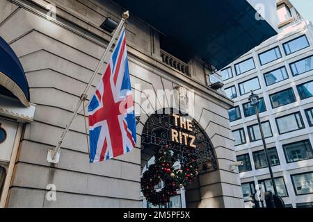 London, Großbritannien - 26. Dezember 2022: Schild vor dem Ritz, Londons berühmtestem Hotel, neben der Flagge des Union Jack an einem Stab. Stockfoto