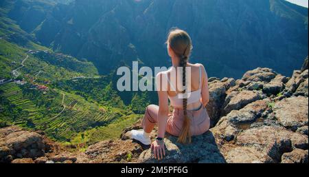Masca-Schlucht und Dorf auf Teneriffa Island. Junge Frau sitzt auf Aussichtspunkt mit tropischer Naturlandschaft. Ländlicher Park von Teno.
