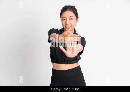 Frau in schwarzer Sportbekleidung, die sich die Hände durch Ziehen der Finger streckt Stockfoto