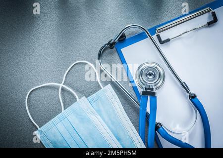 Auscultator Clipboard sterile medizinische Masken auf grauem Hintergrund. Stockfoto