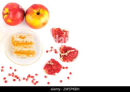 Honigwaben, Granatäpfel und reifer Apfel, isoliert auf weißem Hintergrund. Geben Sie Platz für Text frei. Stockfoto