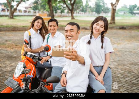 Zwei Schüler Selfie, während sie auf einem Motorrad saßen Stockfoto