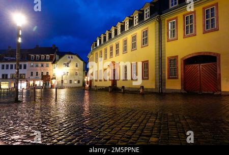 Weimar, Deutschland. 22. Dezember 2022. Das Goethehaus (r) auf dem Frauenplan am Abend, in der Mitte ist das "Gasthaus zum weißen Schwan", links das Haus von Friedrich Schiller. Johann Wolfgang von Goethe lebte im Goethehaus, das 1709 erbaut wurde, für fast 50 Jahre bis zu seinem Tod. Das Gebäude der Klassik Stiftung Weimar, das zum UNESCO-Weltkulturerbe gehört, ist Teil des Ensembles des Goethe-Nationalmuseums und soll ab 2026 renoviert werden. Kredit: Soeren Stache/dpa/Alamy Live News Stockfoto