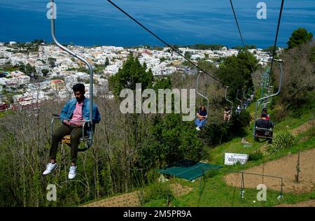 April 24 2022 - Blick auf Anacapri Italien von der Seilbahn mit vielen Touristen auf und ab und blauem Himmel, azurblaues Meer im Hintergrund Stockfoto