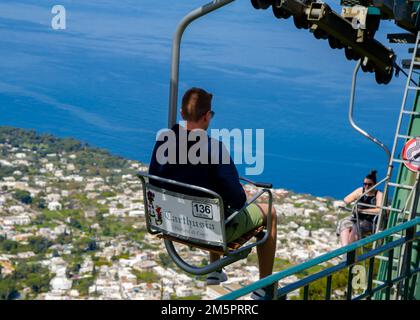 April 24 2022 - Blick auf Anacapri Italien von der Seilbahn mit vielen Touristen auf und ab und blauem Himmel, azurblaues Meer im Hintergrund Stockfoto