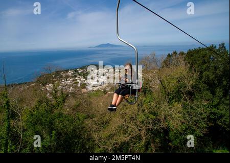 April 24 2022 - Blick auf Anacapri Italien von der Seilbahn mit vielen Touristen auf und ab und blauem Himmel, azurblaues Meer im Hintergrund Stockfoto