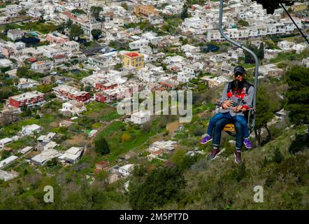 April 24 2022 - Blick auf Anacapri Italien von der Seilbahn mit vielen Touristen auf und ab und blauem Himmel, azurblaues Meer im Hintergrund Stockfoto