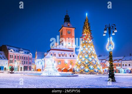 Brasov, Rumänien. Verschneite Nacht mit Weihnachtsmarkt und Baumdekorationen in der Wintersaison im historischen Siebenbürgen. Stockfoto