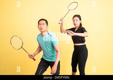 asiatischer Mann und asiatische Frau, die den Schläger halten, bereit für das Shuttle Stockfoto