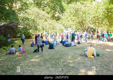 Die Menschen versammeln sich in der Nähe des Kirschbaums, der zum Gedenken an die Opfer von Hiroshima während einer Gedenkveranstaltung am Tavistock Square in London gepflanzt wurde. Stockfoto