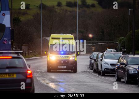 West Yorkshire, Großbritannien. 30. Dezember 2022. Ein Rettungswagen in Halifax, West Yorkshire, nimmt einen Notruf mit eingeschalteten Scheinwerfern und Notbeleuchtung entgegen. Tausende von Krankenwagen-Mitarbeitern im ganzen Land werden im Januar in einem Lohnstreit nach dem Streik der Gewerkschaften mit Sanitätern und 999 Anrufern aus dem Land gehen. Ein für Dezember 28 geplanter Streik der Ambulanzmitarbeiter der GMB-Gewerkschaft wurde bis Januar 11 verschoben, wo auch Mitglieder der Gewerkschaft streiken werden. Kredit: Windmill Images/Alamy Live News Stockfoto