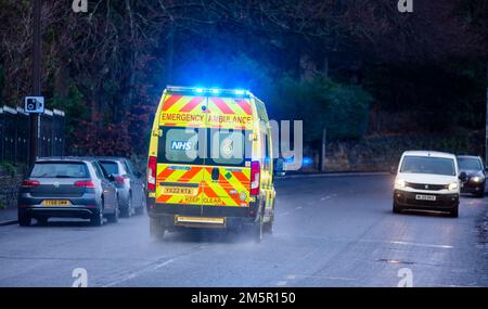 West Yorkshire, Großbritannien. 30. Dezember 2022. Ein Rettungswagen in Halifax, West Yorkshire, nimmt einen Notruf mit eingeschalteten Scheinwerfern und Notbeleuchtung entgegen. Tausende von Krankenwagen-Mitarbeitern im ganzen Land werden im Januar in einem Lohnstreit nach dem Streik der Gewerkschaften mit Sanitätern und 999 Anrufern aus dem Land gehen. Ein für Dezember 28 geplanter Streik der Ambulanzmitarbeiter der GMB-Gewerkschaft wurde bis Januar 11 verschoben, wo auch Mitglieder der Gewerkschaft streiken werden. Kredit: Windmill Images/Alamy Live News Stockfoto