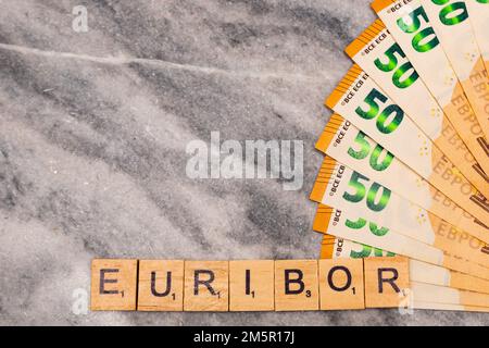 Word EURIBOR ist in Holzbuchstaben geschrieben, nahe eines Teils von 50 Euro-Banknoten. Stockfoto