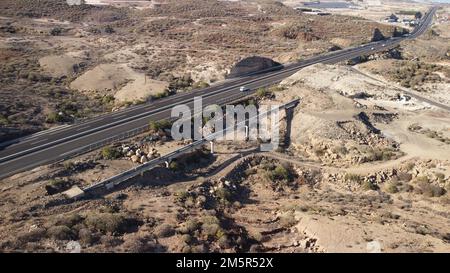 Ein Luftblick auf die Autobahn, die durch die Wüste von Teneriffa führt, die Kanarischen Inseln in Spanien Stockfoto