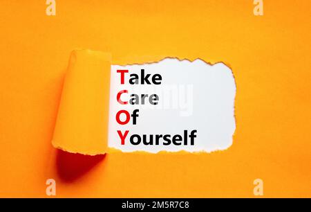 TCOY Acht auf dich Symbol. Konzeptbegriffe TCOY auf weißem Papier auf schönem orangefarbenen Tischhintergrund sollten Sie auf sich aufpassen. Business TCOY Stockfoto