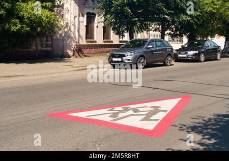 Bobruisk, Weißrussland, 11. August 2022: Auf der Asphaltstraße wird ein Schild gezeichnet - Achtung Kinder, Autos stehen in der Nähe. Stockfoto