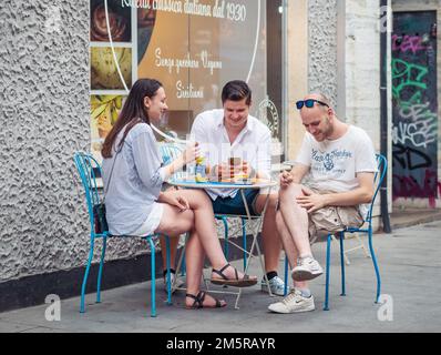 Bukarest, Rumänien - August 2022: Urbane Szene mit Menschen, die an Tischen sitzen und einen Drink in der Altstadt von Bukarest genießen Stockfoto