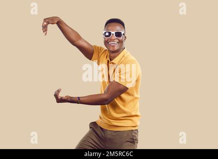 Ein komischer, dunkelhäutiger Mann mit beiden Händen tut so, als würde er ein Objekt halten, das seine Größe zeigt. Stockfoto