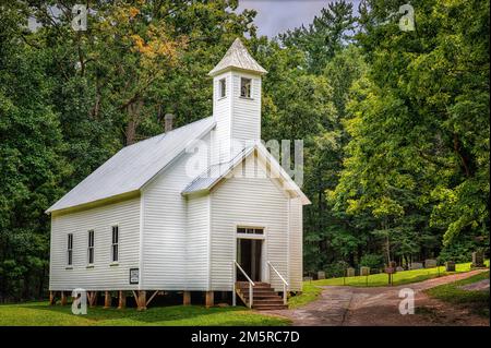 Die über 100 Jahre alte Cades Cove Pioneer Missionary Baptist Church im Spätsommer, genau wie der erste Hauch von Herbstlaub zu sehen beginnt. Stockfoto