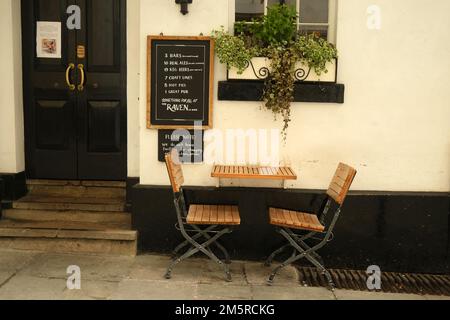 November 2022 - während des Weihnachtsmarkts in Bath, England, Großbritannien, wurden auf der Straße leere Cafétische und Stühle aufgestellt. Stockfoto