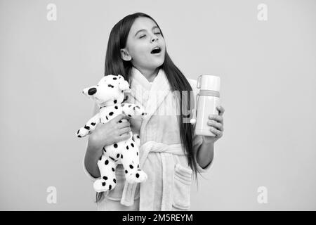 Kindheit Glück. Guten Morgen. Sleepy Kind tragen Nachthemd spielen mit Spielzeug. Kind in gemütlichen Schlafbekleidung. Stockfoto