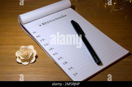 RESOLUTION ist auf einem Notizblock oder Buch zusammen mit einem Stift auf dem Tisch geschrieben. Stockfoto