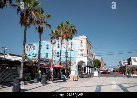 Blick auf Geschäfte und Palmen auf der Promenade am Venice Beach an sonnigen Tagen Stockfoto