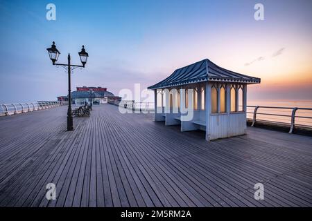 Ein zarter Sonnenaufgang über dem Cromer Pier an der Nordküste von Norfolk Stockfoto