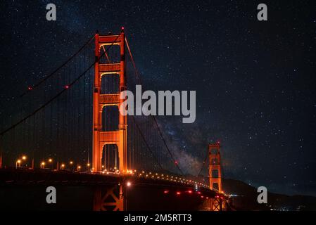 Beleuchtete Golden Gate Hängebrücke unter einem wunderschönen Sternenfeld bei Nacht Stockfoto