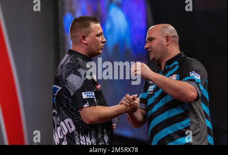 Chris Dobey schüttelt mit Rob Cross die Hand, nachdem er am 13. Tag der Cazoo Dart-Weltmeisterschaft im Alexandra Palace, London, sein Spiel gewonnen hat. Foto: Freitag, 30. Dezember 2022. Stockfoto