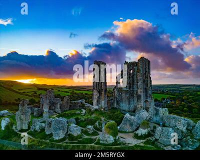 Eine Luftaufnahme einer alten Ruine von Corfe Castle, Dorset, während des Sonnenuntergangs Stockfoto