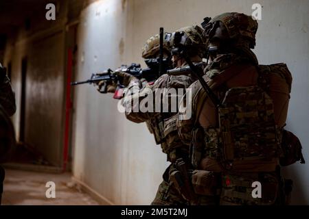 USA Armeesoldaten, Alpha-Kompanie zugewiesen, 1. Bataillon, 125. Infanterie-Regiment, 37. Infanterie-Brigaden-Kampfteam, Task Force Reaper, kombinierte gemeinsame Task Force - Operation inhärent Resolve, sicheres Sichern eines Gebäudes für Bedrohungen während einer kombinierten Übung, Al Asad Air Base, Irak, 22. Dezember 2022. Gemeinsame Schulungsveranstaltungen zwischen Koalitionspartnern tragen dazu bei, die Bereitschaft für gemeinsame Operationen während der Basisverteidigungsoperationen aufrechtzuerhalten. (USA Armeefoto von Sergeant Julio Hernandez) Stockfoto