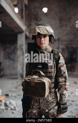 Porträt einer Militärfrau in einem zerstörten Gebäude. Ukrainische Kriegsverteidigerin. Stockfoto